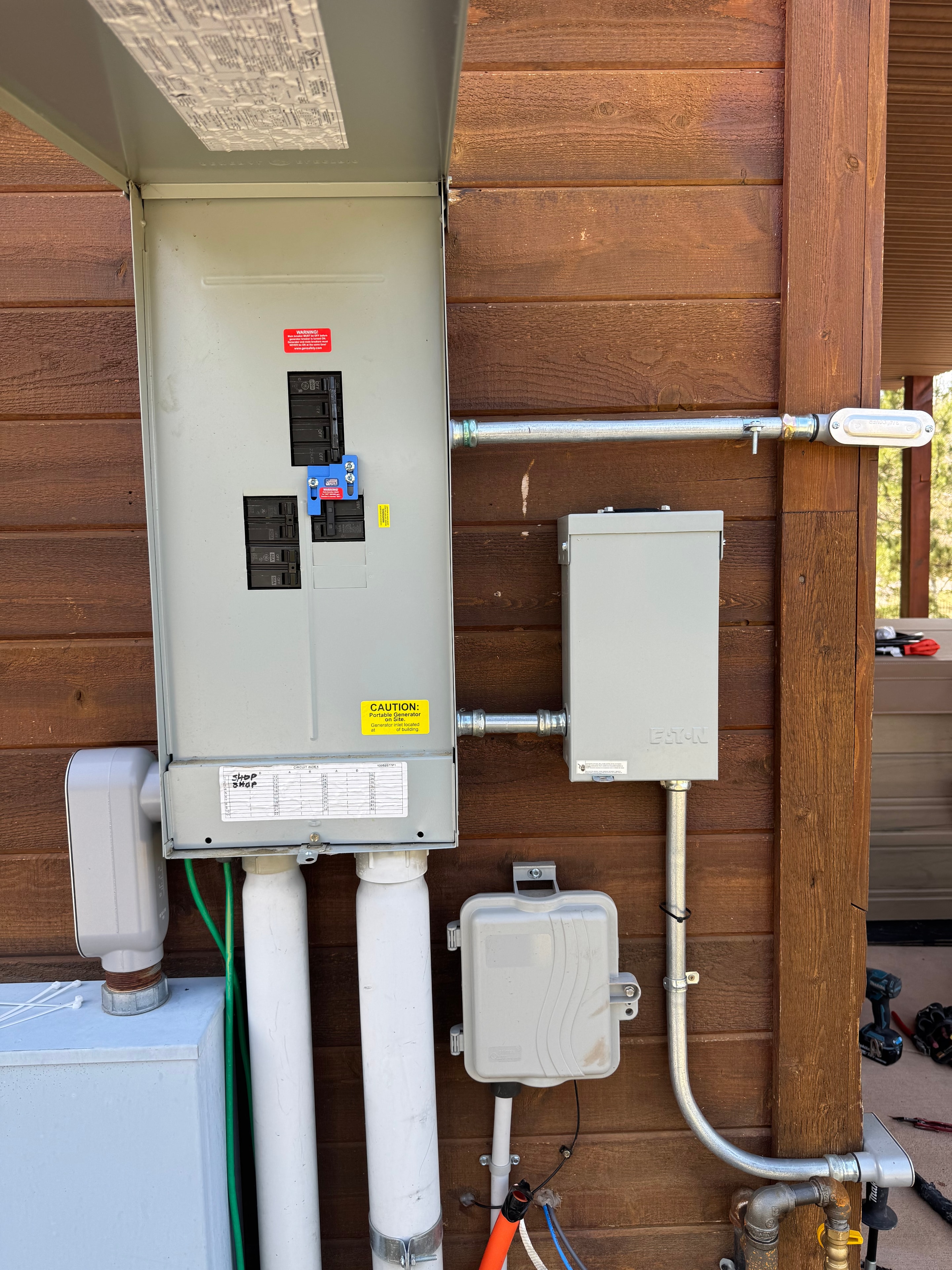 Portable generator hookup with safety interlock installed at a mountain property